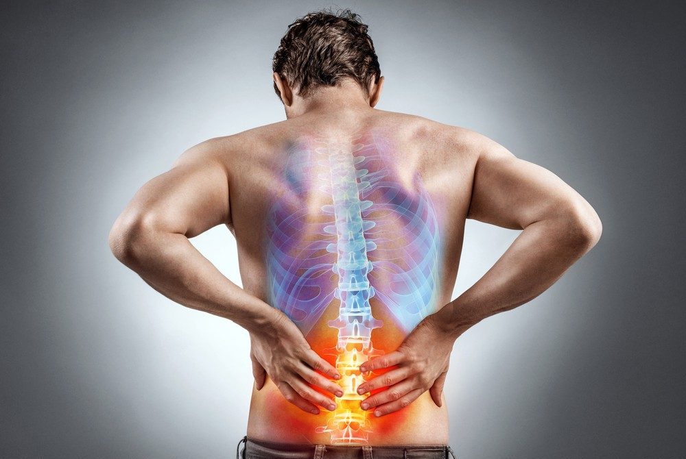 Man holding his lower back showing signs of spinal discomfort – Russell Lea chiropractor care